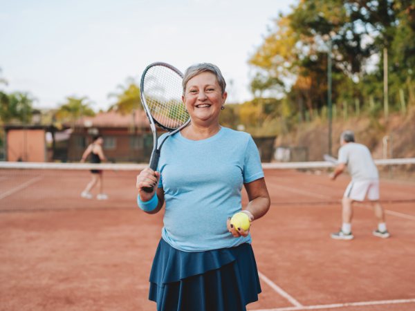 Ältere Frau mit Tennisschläger.